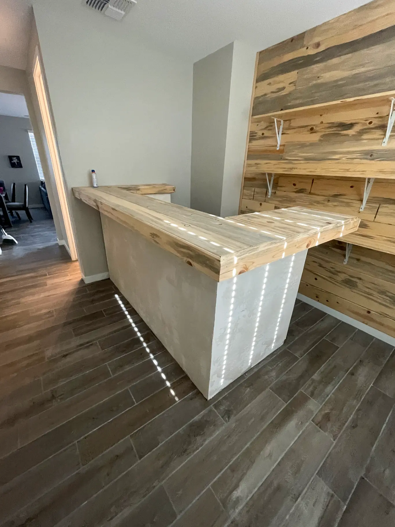 Close view of crisp caulk lines where a painted shiplap wall meets a stained bar in a Phoenix home